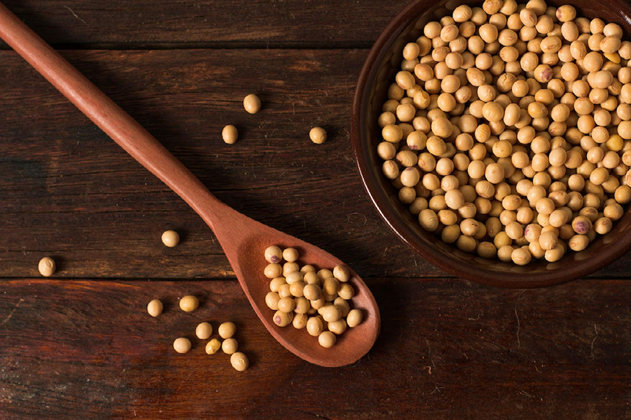 raw and fresh soy beans inside brown ceramic bowl on rustic wooden table